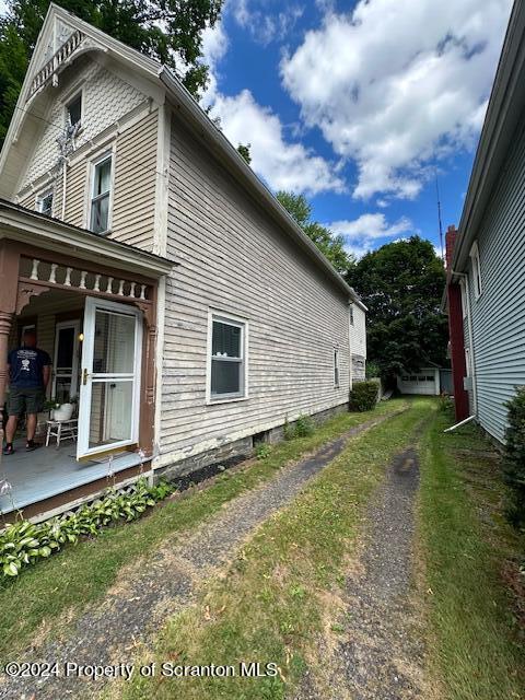 view of side of home featuring covered porch