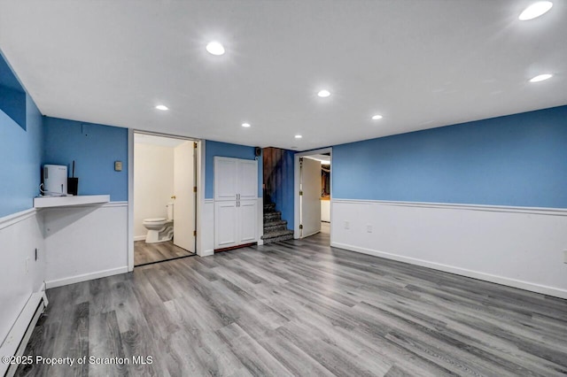 211 Hill St, Dupont, PA 18641 - unfurnished living room featuring a baseboard radiator, stairs, wood finished floors, and recessed lighting