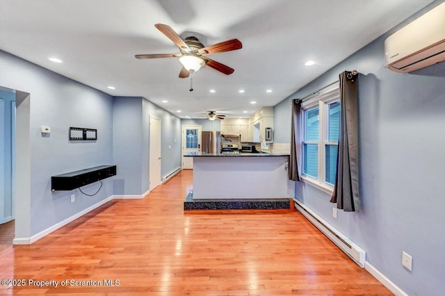 211 Hill St, Dupont, PA 18641 - kitchen with a wall unit AC, ceiling fan, freestanding refrigerator, baseboard heating, and a peninsula