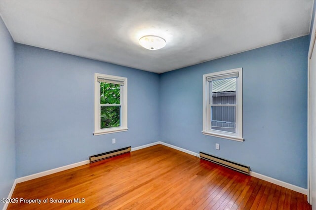 211 Hill St, Dupont, PA 18641 - empty room with a baseboard heating unit and hardwood / wood-style flooring