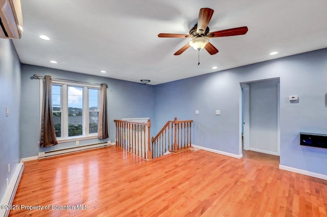 211 Hill St, Dupont, PA 18641 - empty room with baseboard heating, a baseboard radiator, an AC wall unit, wood finished floors, and recessed lighting