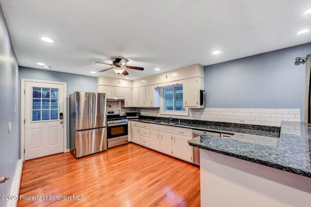 211 Hill St, Dupont, PA 18641 - kitchen featuring appliances with stainless steel finishes, ceiling fan, light wood-style floors, decorative backsplash, and under cabinet range hood