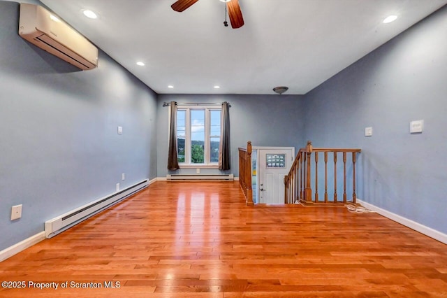 211 Hill St, Dupont, PA 18641 - unfurnished room with baseboard heating, an AC wall unit, wood finished floors, a baseboard radiator, and recessed lighting
