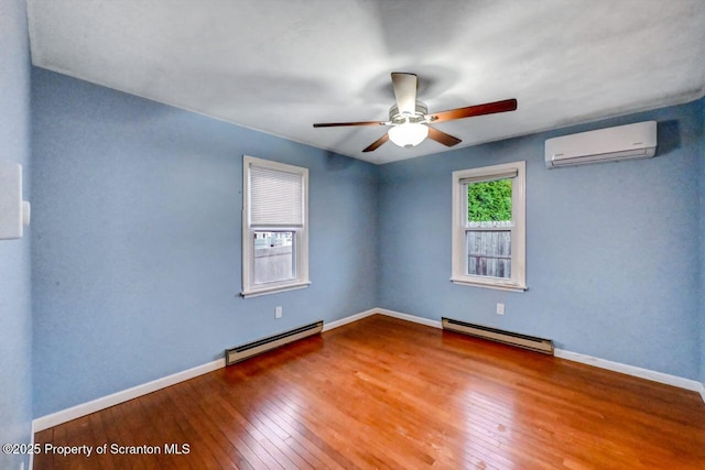 211 Hill St, Dupont, PA 18641 - spare room featuring baseboard heating, a wall mounted AC, hardwood / wood-style flooring, and ceiling fan