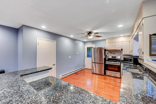 211 Hill St, Dupont, PA 18641 - kitchen with appliances with stainless steel finishes, baseboard heating, light wood-style floors, a ceiling fan, and tasteful backsplash
