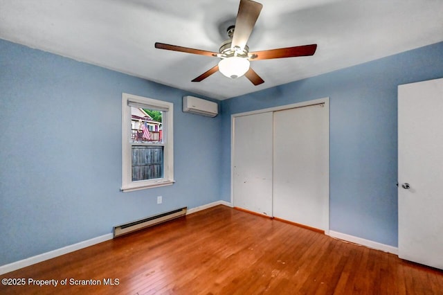 211 Hill St, Dupont, PA 18641 - unfurnished bedroom with a baseboard heating unit, a wall unit AC, wood finished floors, a closet, and ceiling fan