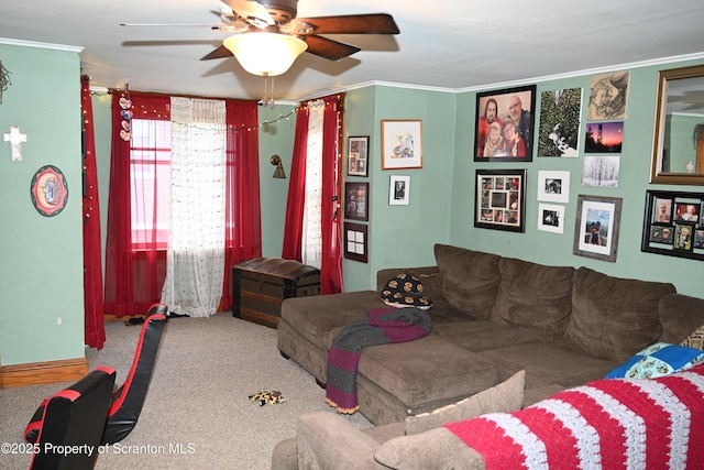 carpeted living room with ornamental molding and ceiling fan