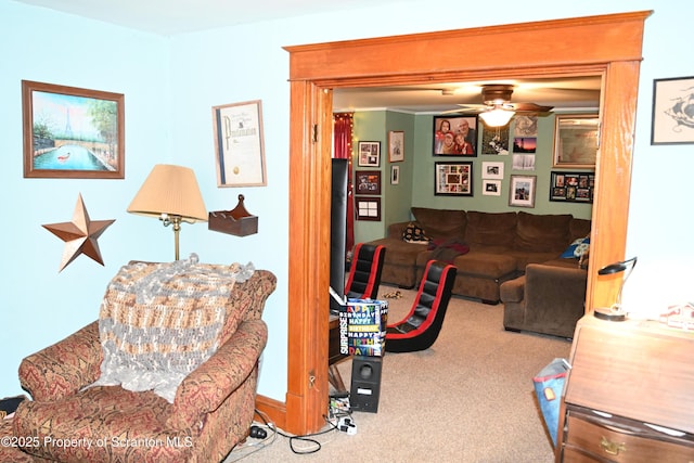 living area featuring carpet and a ceiling fan