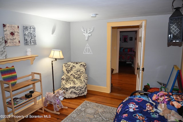 bedroom featuring wood finished floors and baseboards