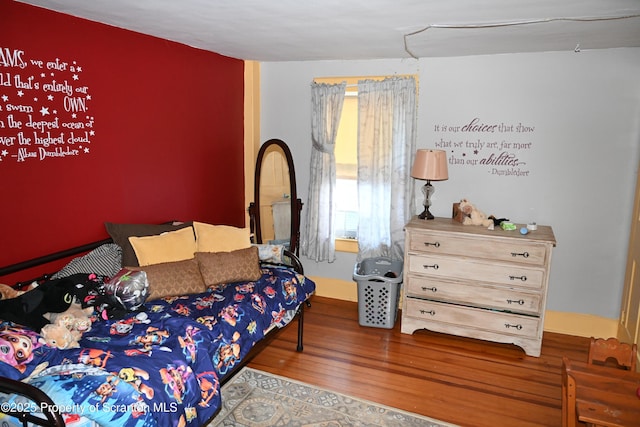 bedroom featuring wood finished floors and baseboards