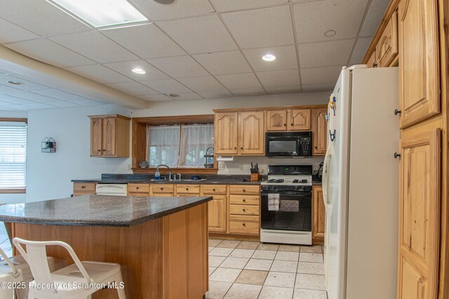 72 Adams Dr, Waymart, PA 18472 - kitchen featuring black microwave, range with gas stovetop, freestanding refrigerator, a breakfast bar area, and a center island
