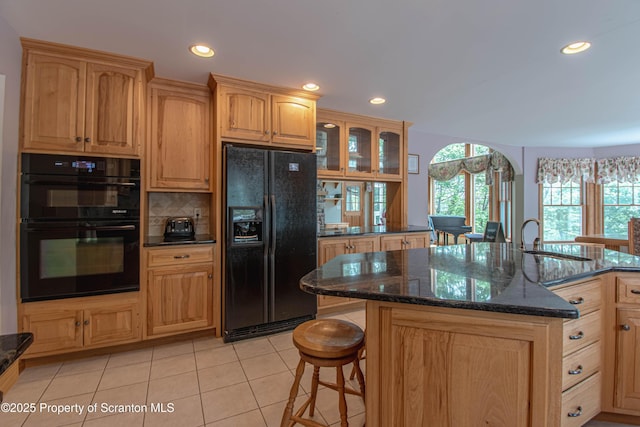 72 Adams Dr, Waymart, PA 18472 - kitchen with black appliances, a kitchen breakfast bar, light tile patterned flooring, dark stone counters, and recessed lighting