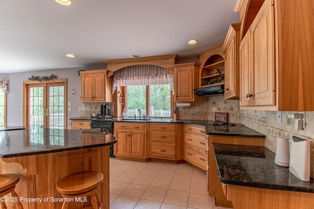 72 Adams Dr, Waymart, PA 18472 - kitchen with dishwasher, under cabinet range hood, light tile patterned floors, decorative backsplash, and a kitchen breakfast bar