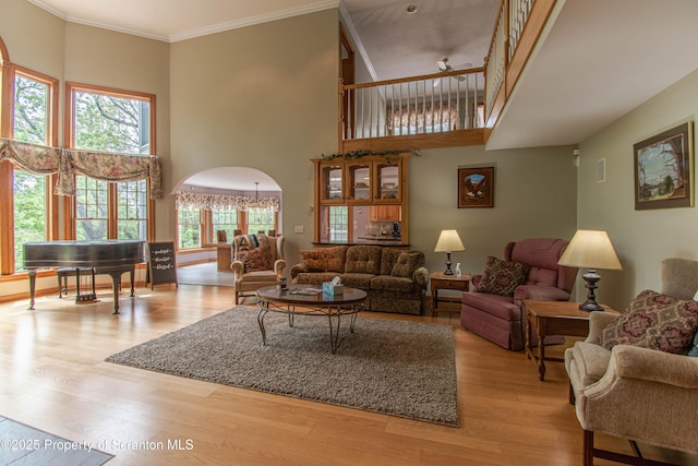 72 Adams Dr, Waymart, PA 18472 - living room featuring a high ceiling, wood finished floors, arched walkways, a ceiling fan, and ornamental molding