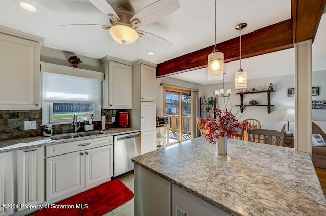 kitchen featuring sink, light stone counters, stainless steel dishwasher, decorative light fixtures, and decorative backsplash