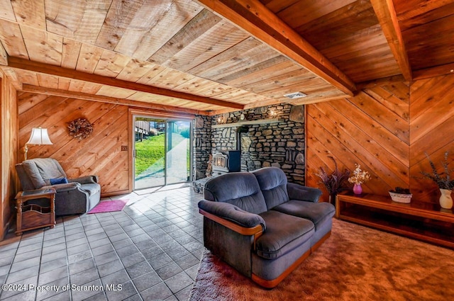 living room with wooden walls, wooden ceiling, beamed ceiling, tile patterned flooring, and a wood stove