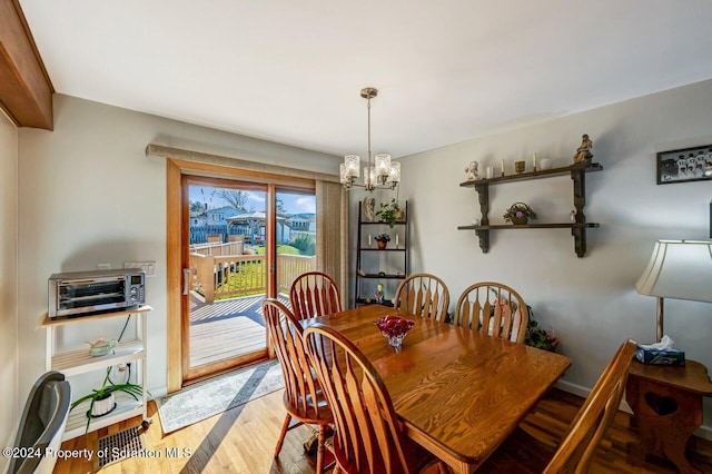 dining space featuring hardwood / wood-style flooring and a notable chandelier