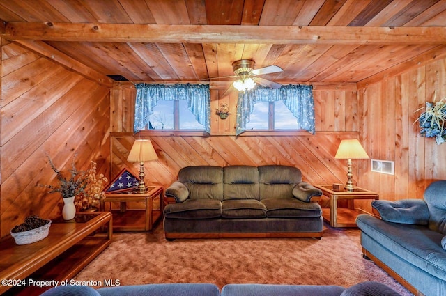 carpeted living room with beam ceiling, ceiling fan, wooden walls, and wooden ceiling