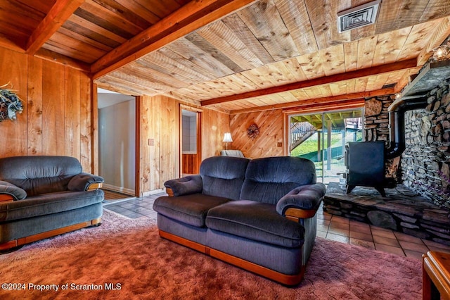 tiled living room featuring wood ceiling, beam ceiling, a wood stove, and wooden walls