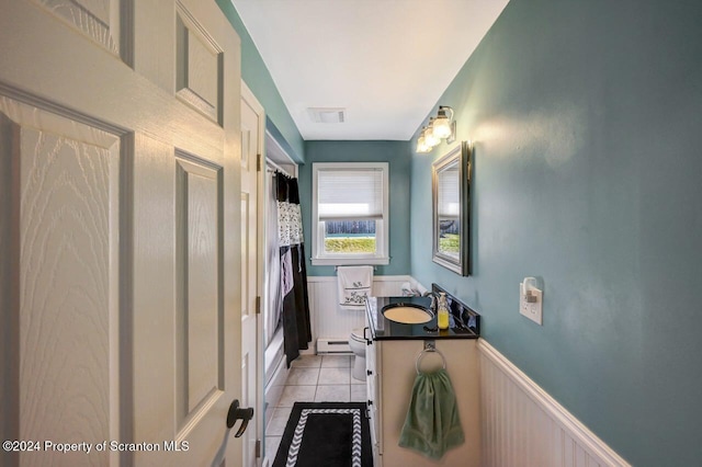 bathroom featuring toilet, vanity, tile patterned floors, and a baseboard heating unit