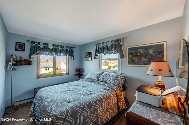 bedroom with carpet floors and a baseboard heating unit