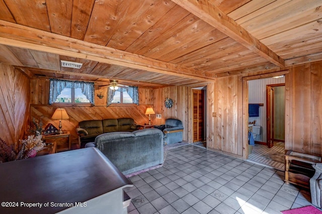 tiled living room featuring beamed ceiling, ceiling fan, wood walls, and wooden ceiling