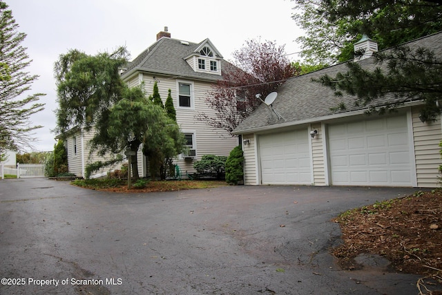 525 N Abington Rd, Waverly Twp, PA 18411 - view of side of home with a chimney, a garage, asphalt driveway, and a shingled roof
