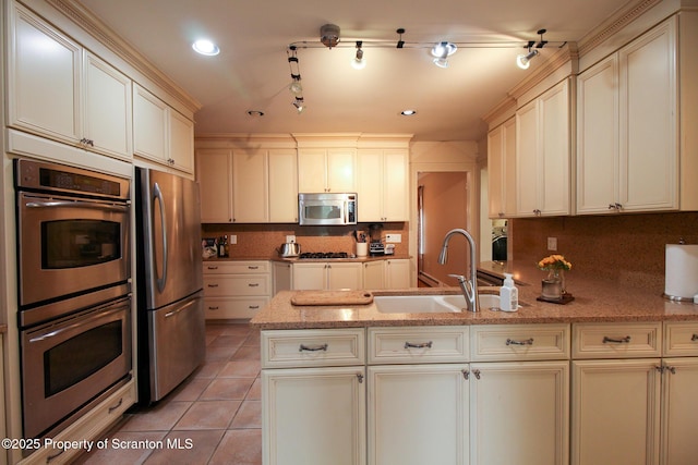 525 N Abington Rd, Waverly Twp, PA 18411 - kitchen featuring stainless steel appliances, a sink, a peninsula, tasteful backsplash, and cream cabinetry