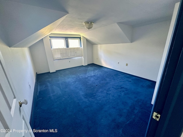 bonus room featuring dark carpet and lofted ceiling