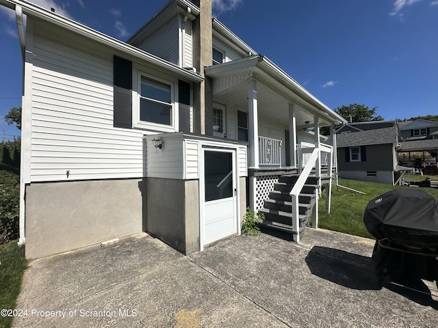 entrance to property with a lawn and covered porch