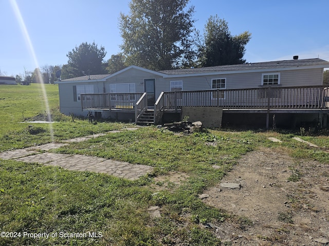 manufactured / mobile home with a deck and a front yard