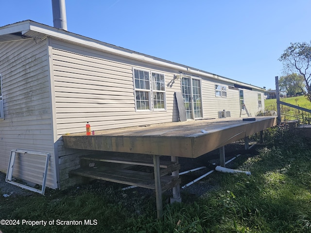 back of house featuring central air condition unit and a wooden deck