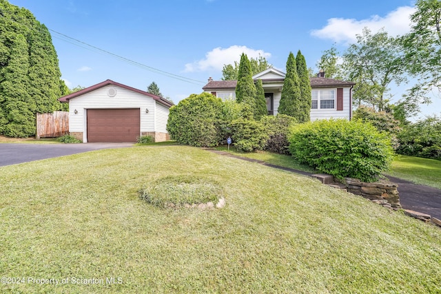 view of front of property featuring a garage, an outbuilding, and a front yard