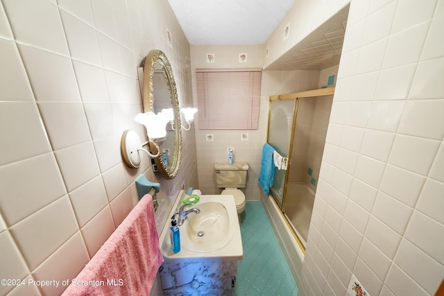 bathroom featuring tile walls, toilet, walk in shower, and sink