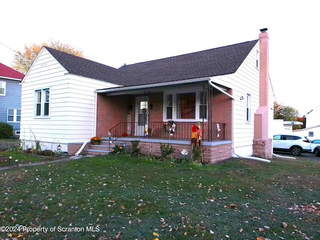 view of front of house featuring covered porch and a front lawn