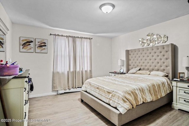 bedroom with light hardwood / wood-style flooring and a baseboard radiator