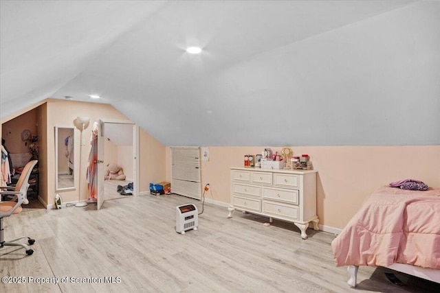 bedroom with lofted ceiling and light wood-type flooring