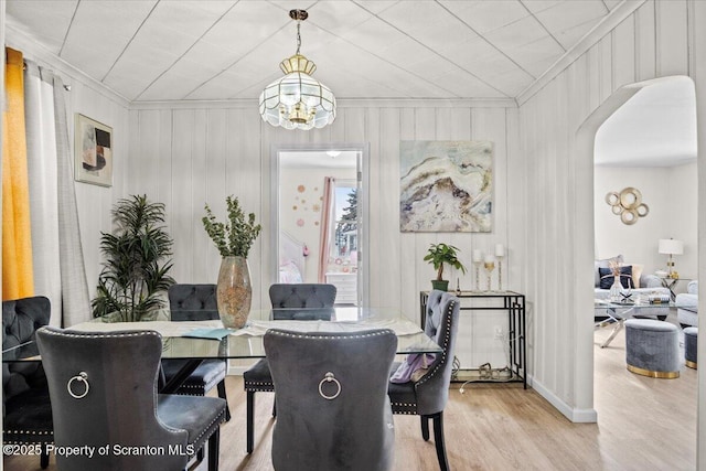 dining space with light hardwood / wood-style flooring and ornamental molding