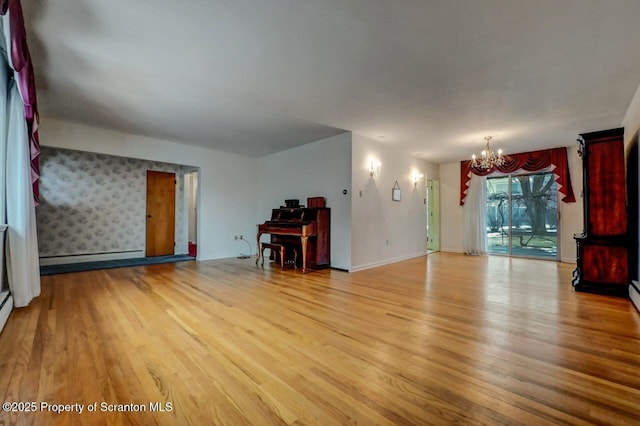 unfurnished living room featuring a notable chandelier, light hardwood / wood-style floors, and a baseboard heating unit