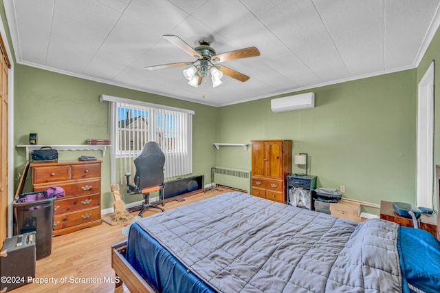 bedroom with a wall mounted air conditioner, ornamental molding, ceiling fan, wood-type flooring, and radiator heating unit