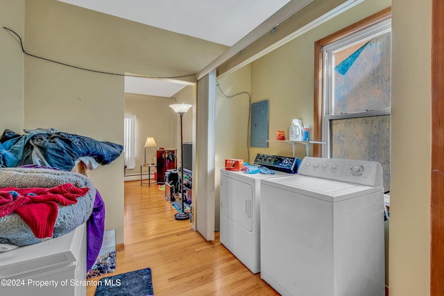 laundry room with electric panel, baseboard heating, light hardwood / wood-style floors, and washing machine and clothes dryer