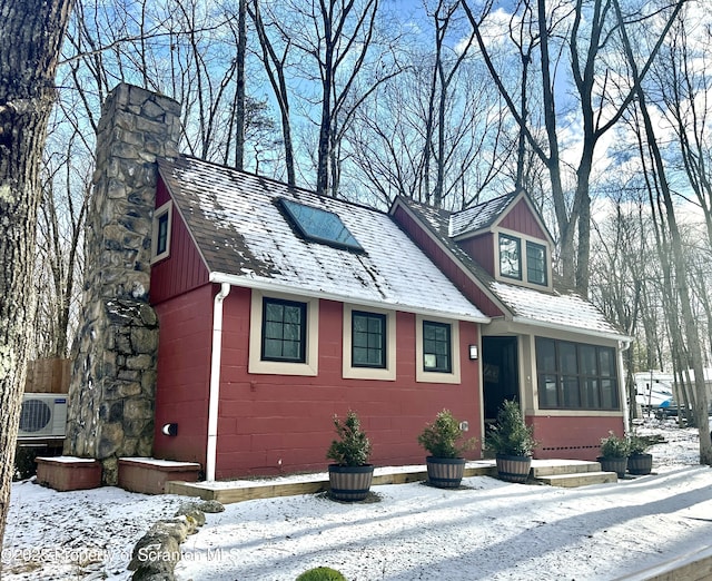 view of front of property featuring a sunroom and ac unit