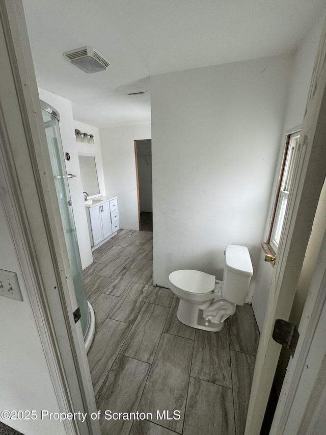 bathroom with vanity, toilet, and visible vents