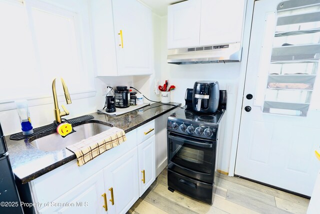 kitchen with under cabinet range hood, white cabinetry, a sink, and black / electric stove