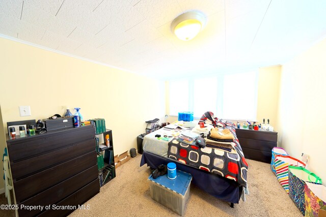bedroom with ornamental molding and carpet