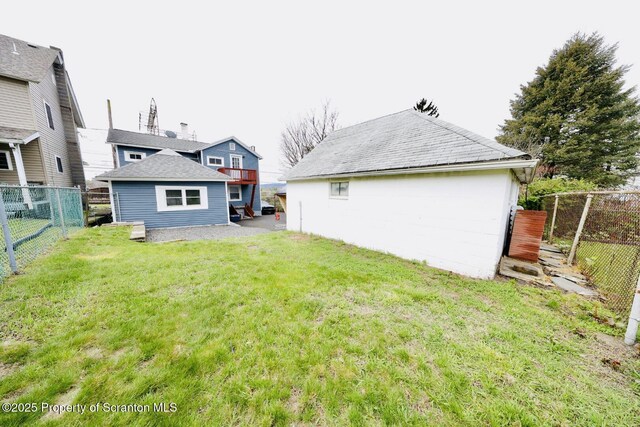rear view of property with a fenced backyard and a lawn