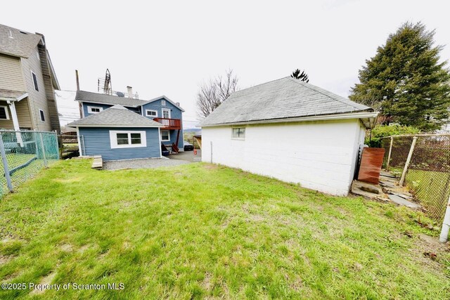 back of property featuring a yard, an outbuilding, and a fenced backyard
