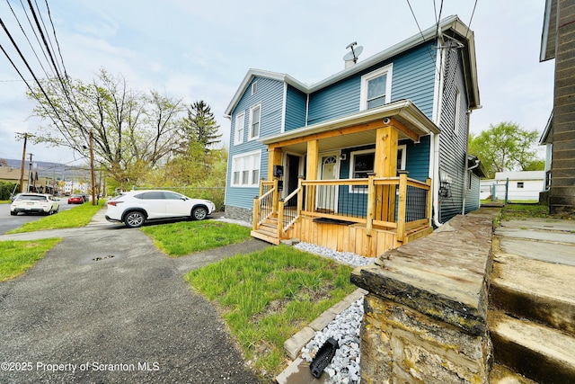 view of front of house featuring a porch and a chimney