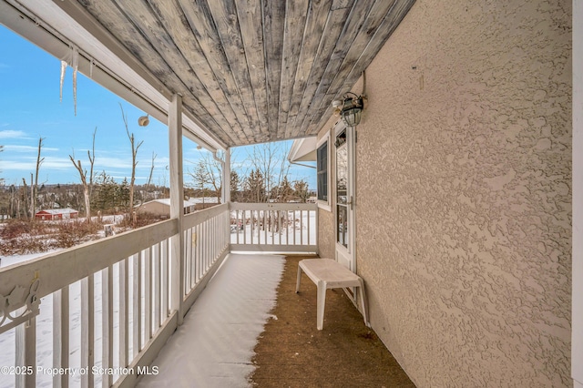 view of snow covered back of property