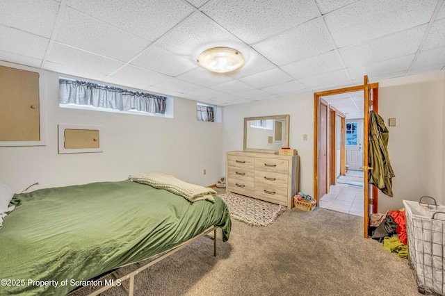 carpeted bedroom with a paneled ceiling